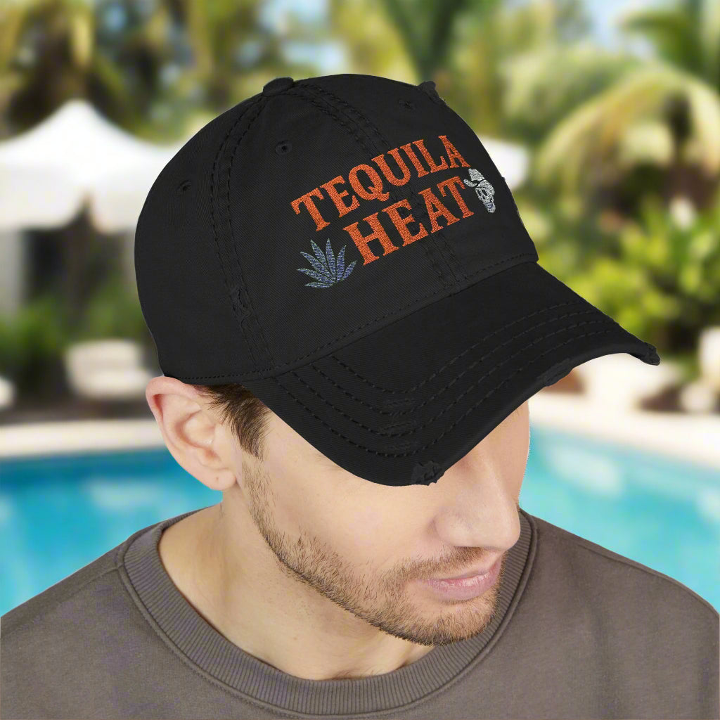 Black cap with 'Tequila Heat' text worn by a person near a pool