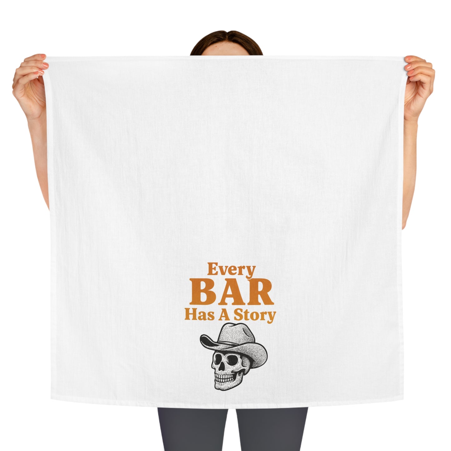 Person holding a white towel with 'Every Bar Has A Story' text and skull graphic.