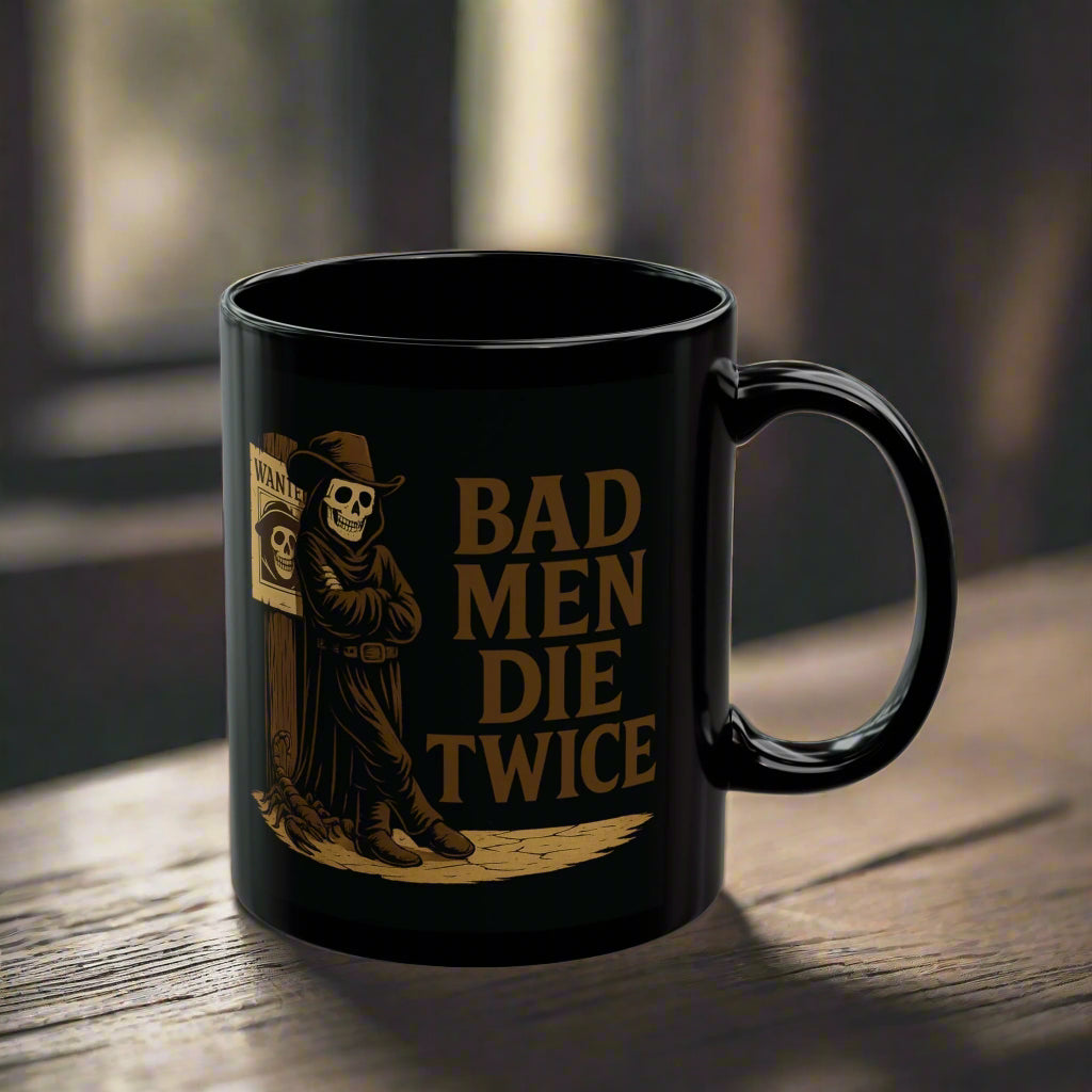 Black mug with 'Bad Men Die Twice' design on a wooden surface