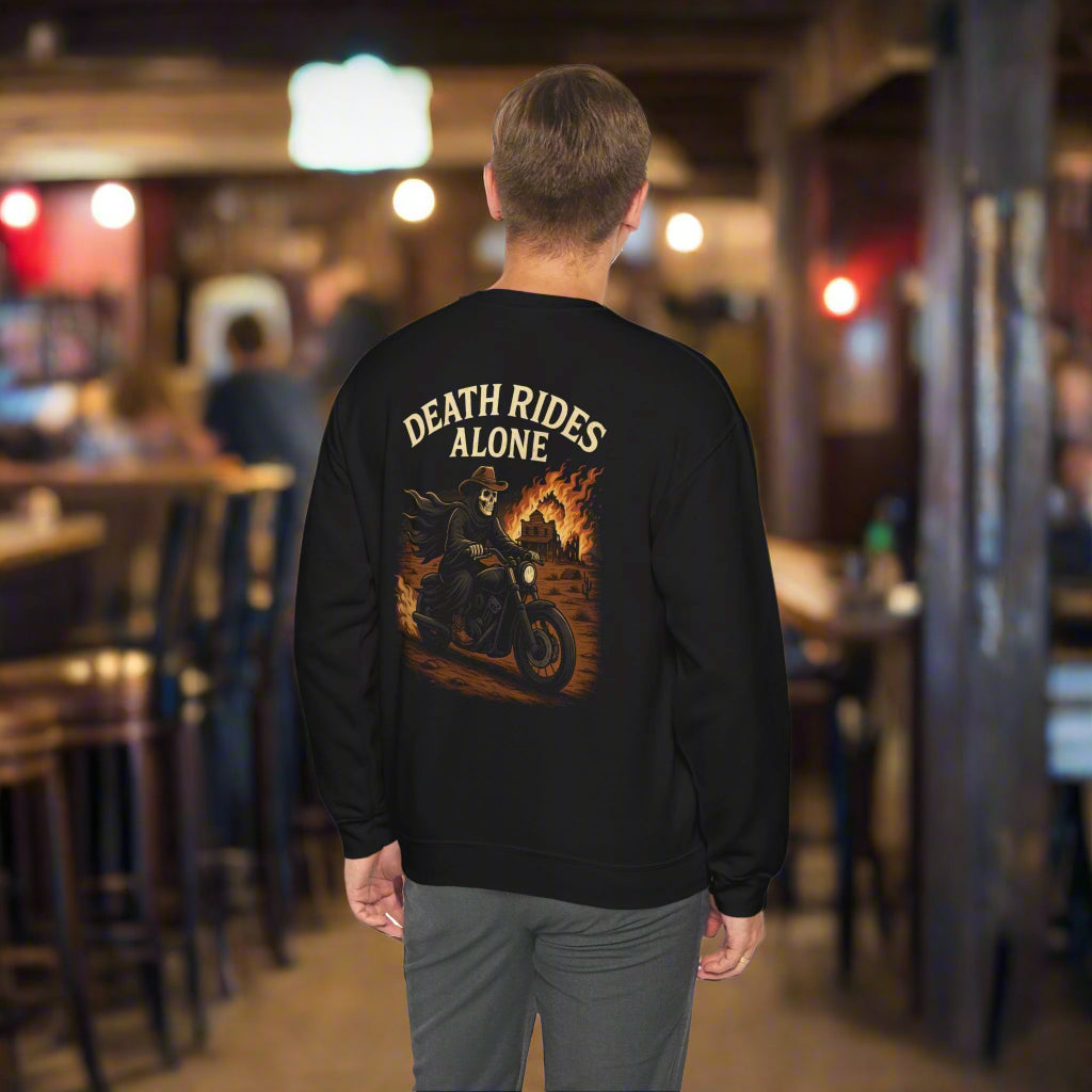 Person wearing a black sweatshirt with 'Death Rides Alone' graphic in a bar setting